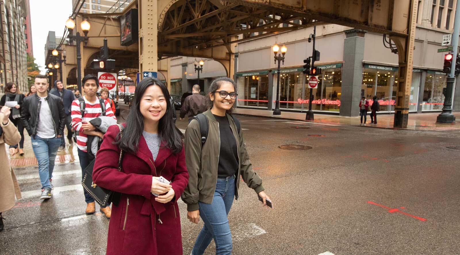 Diverse group of students crosses a cross walk in the city